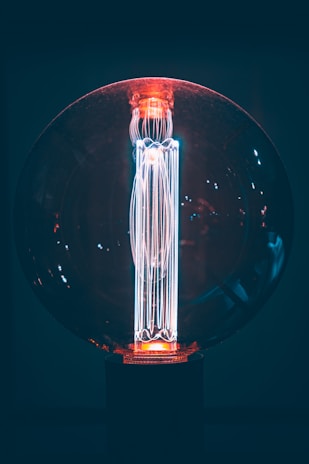 A sleek smart LED bulb with a glowing blue light indicating connectivity.