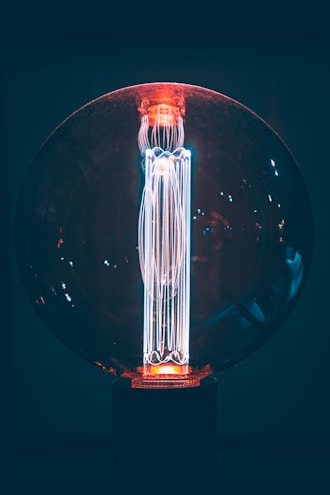 A sleek smart LED bulb with a glowing blue light indicating connectivity.