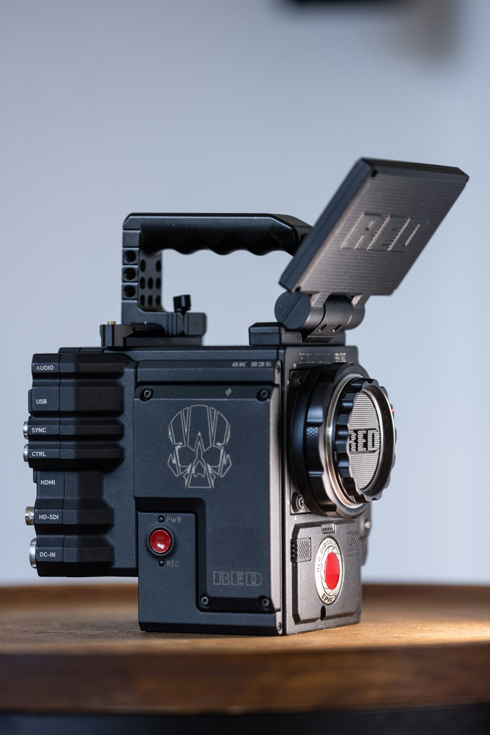 Schwarz-rote Kamera auf braunem Holztisch