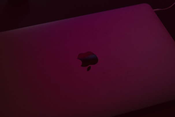 Apple MacBook open on a desk with natural light highlighting its thin design.