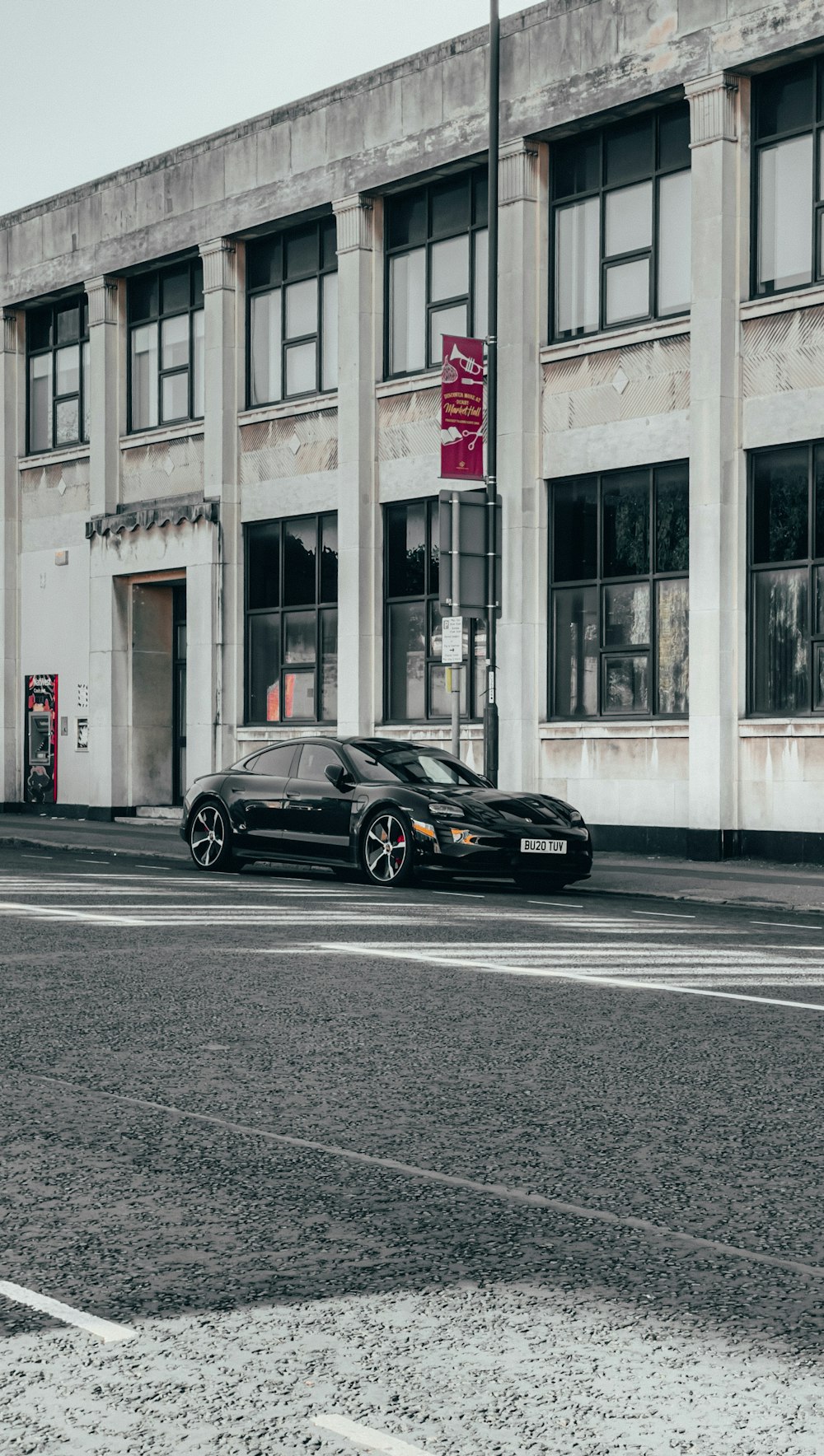 a black car is parked in front of a building