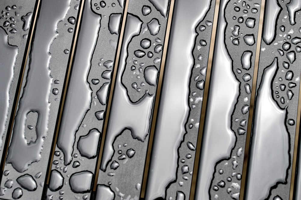 a close up of water droplets on a metal surface