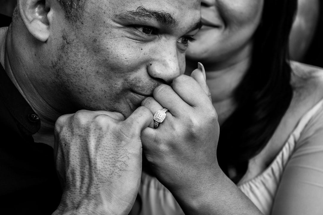 grayscale photo of woman putting her hand on her face