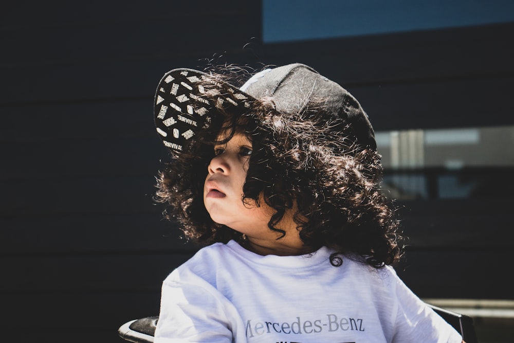 girl in white crew neck shirt wearing black and white polka dot hat