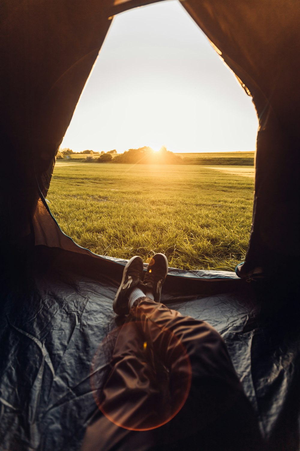 a person laying in a tent in a field