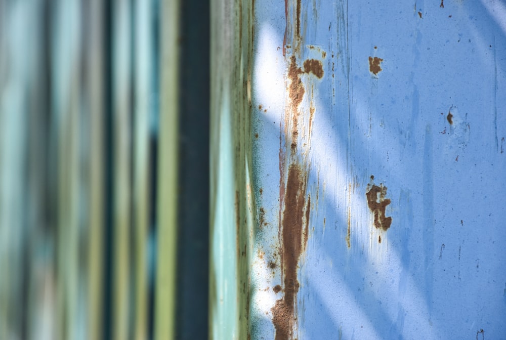 a rusted metal wall with a blue sky in the background