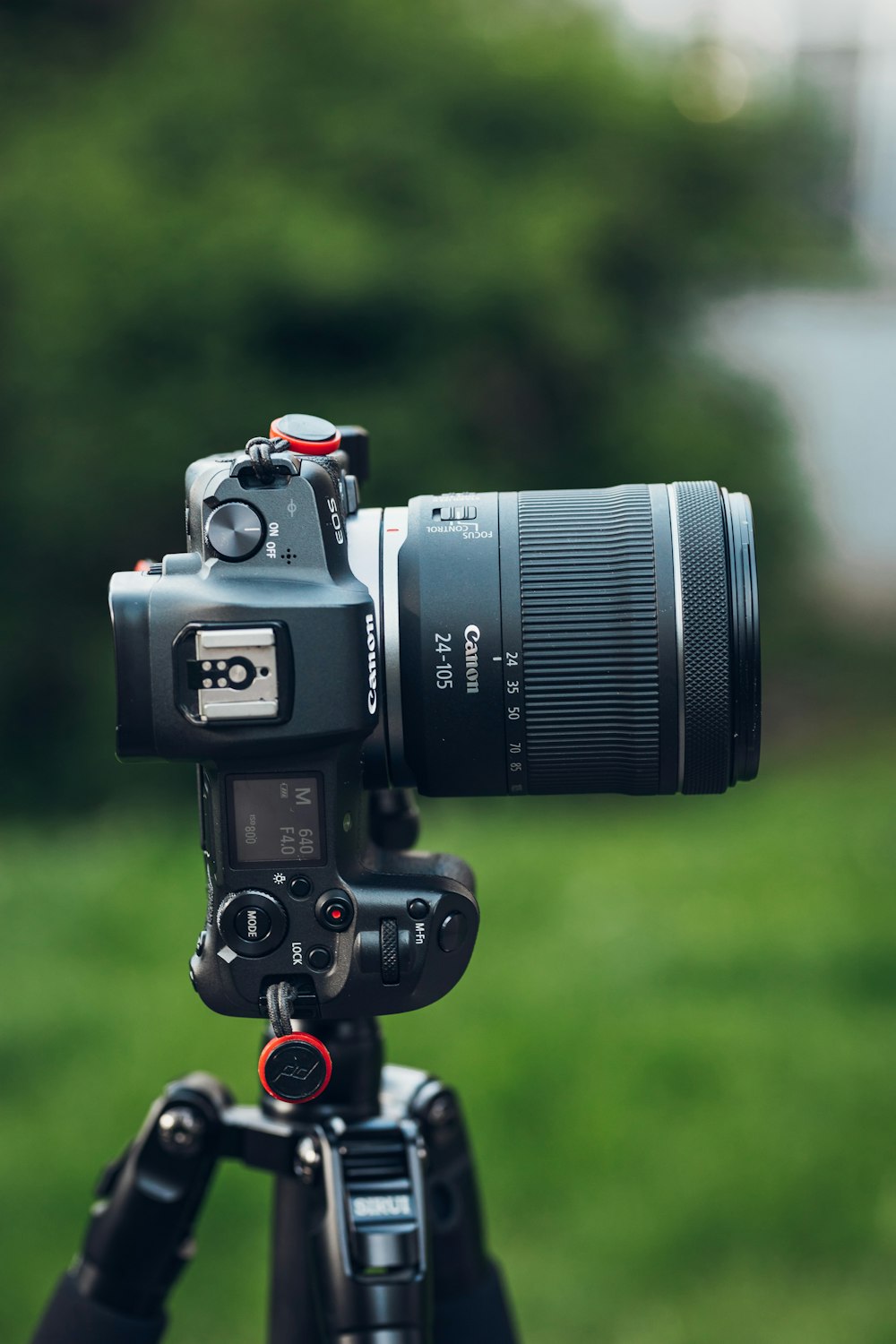 black nikon dslr camera on green grass during daytime