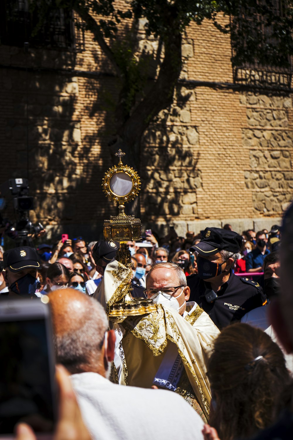 people in gold and black costume standing near brown brick wall during daytime