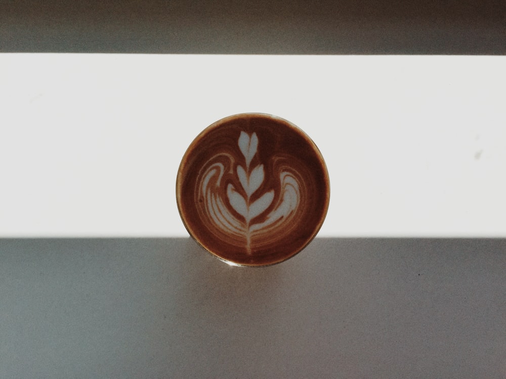 a cup of coffee with a leaf design on it