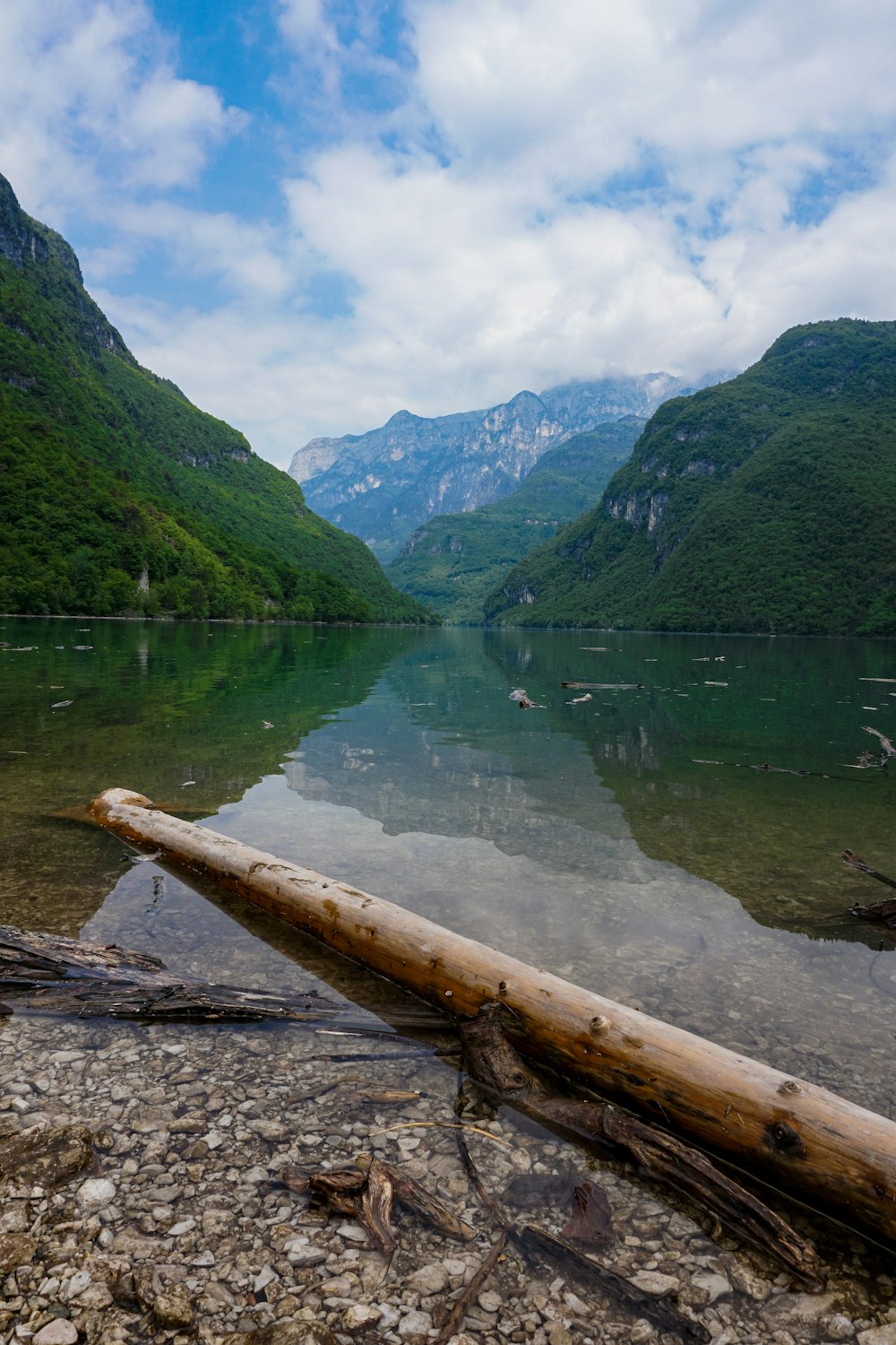 green mountains beside lake under blue sky during daytime