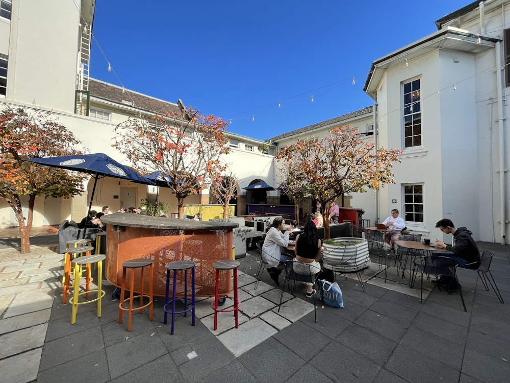 a group of people sitting at tables outside of a building