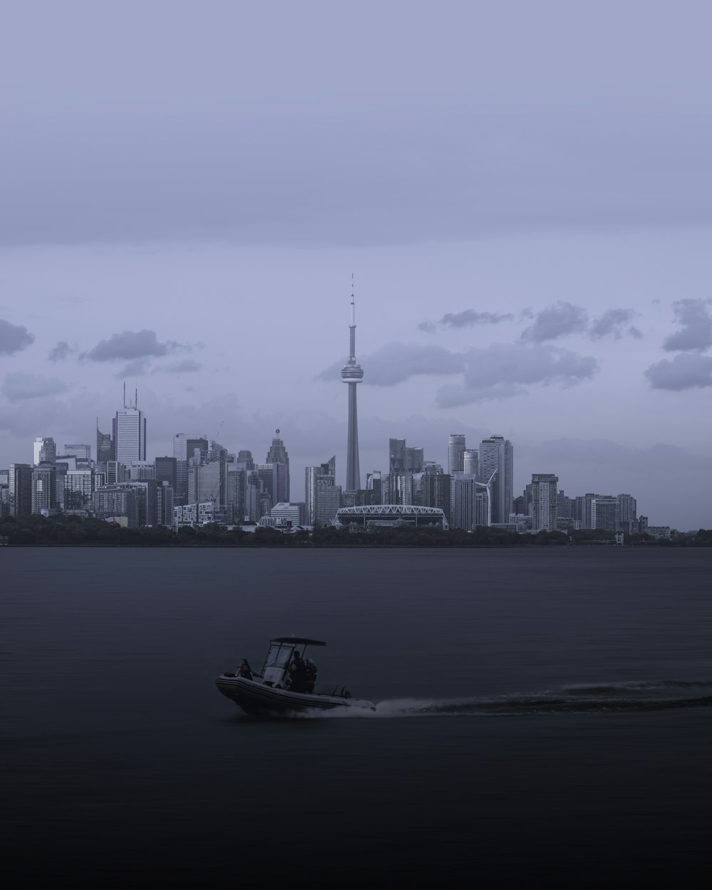 white boat on sea near city buildings during daytime