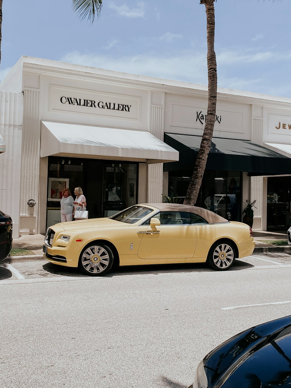 yellow porsche 911 parked near white concrete building during daytime