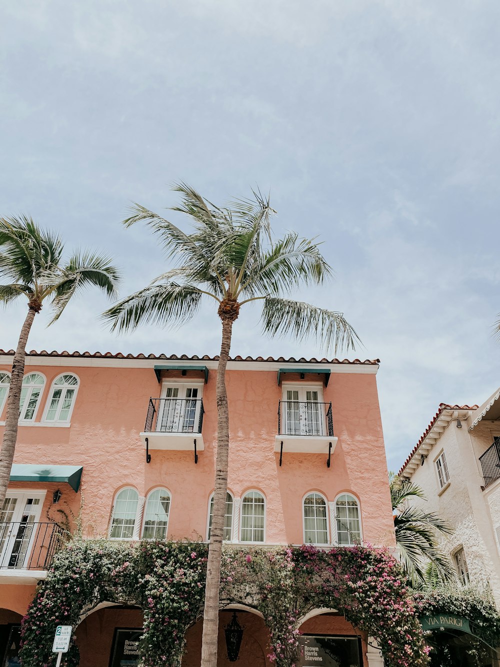 a pink building with palm trees in front of it