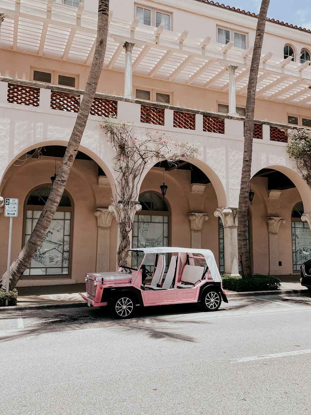 red and white car parked beside brown concrete building during daytime