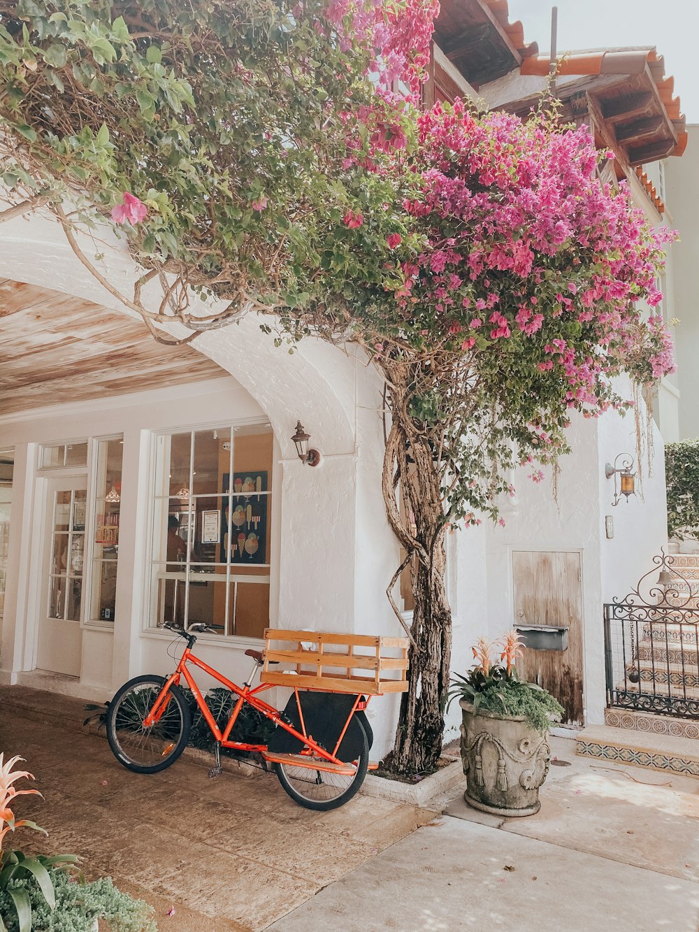 red bicycle parked beside white concrete building during daytime