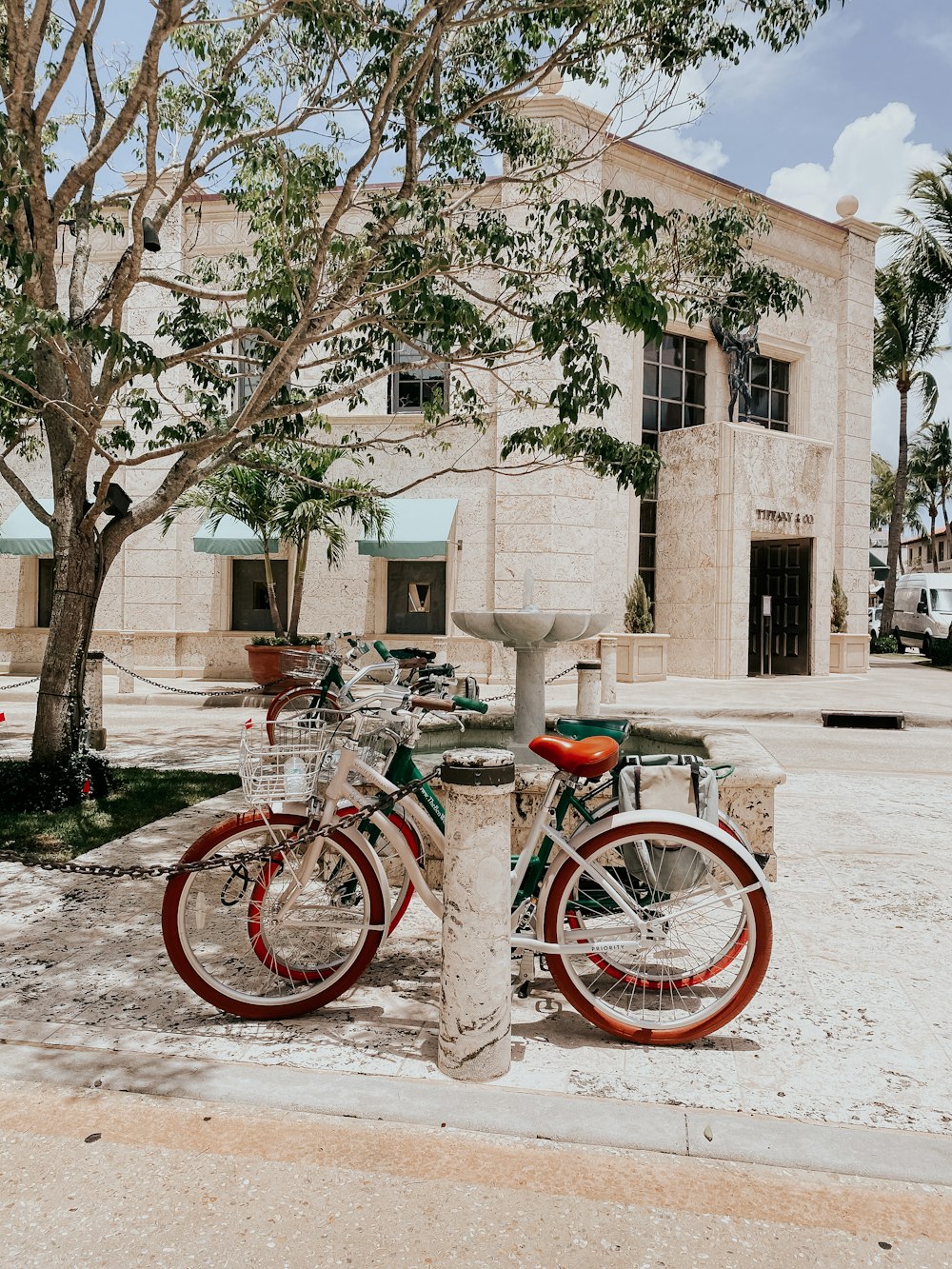 red city bike parked beside brown bare tree during daytime