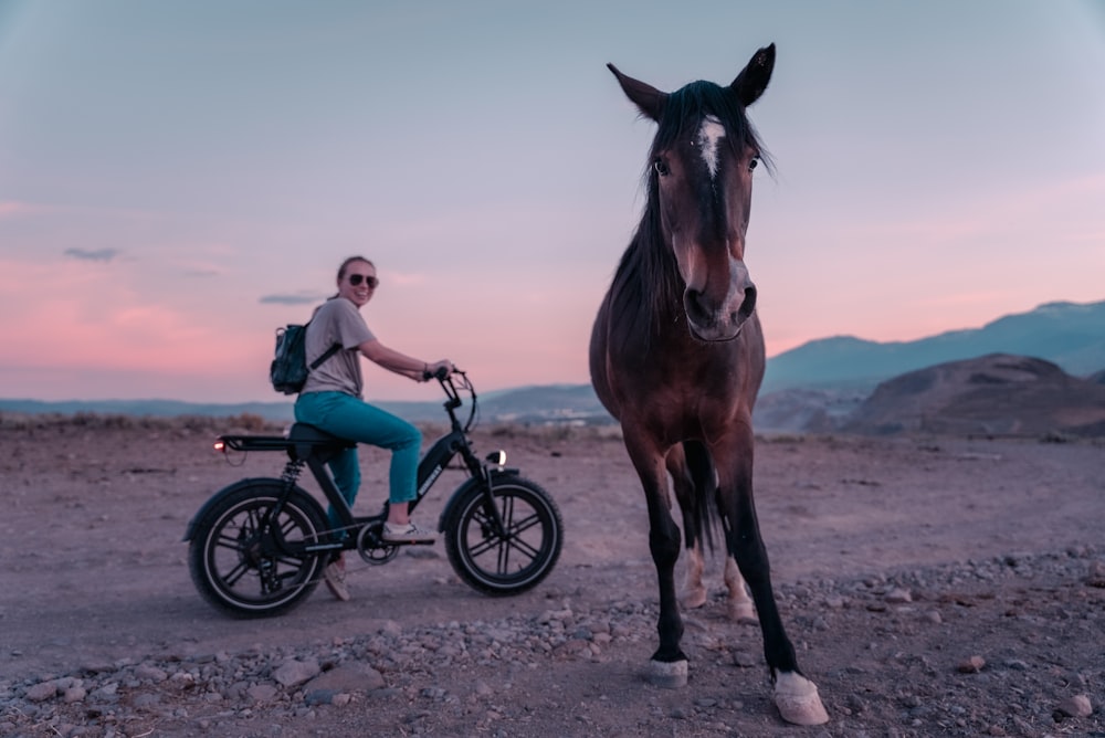 woman in white long sleeve shirt riding on brown horse during daytime