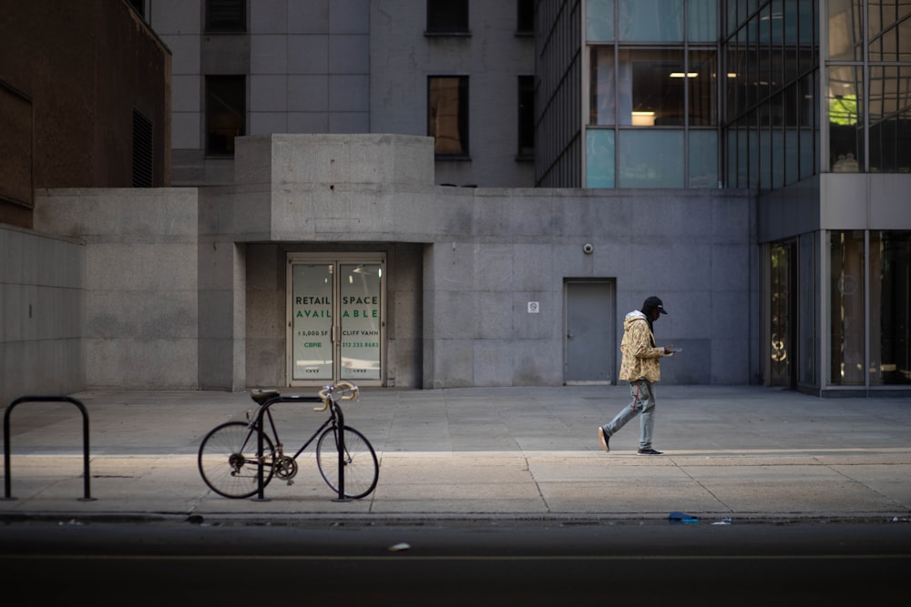 man in brown jacket riding on bicycle near gray concrete building during daytime