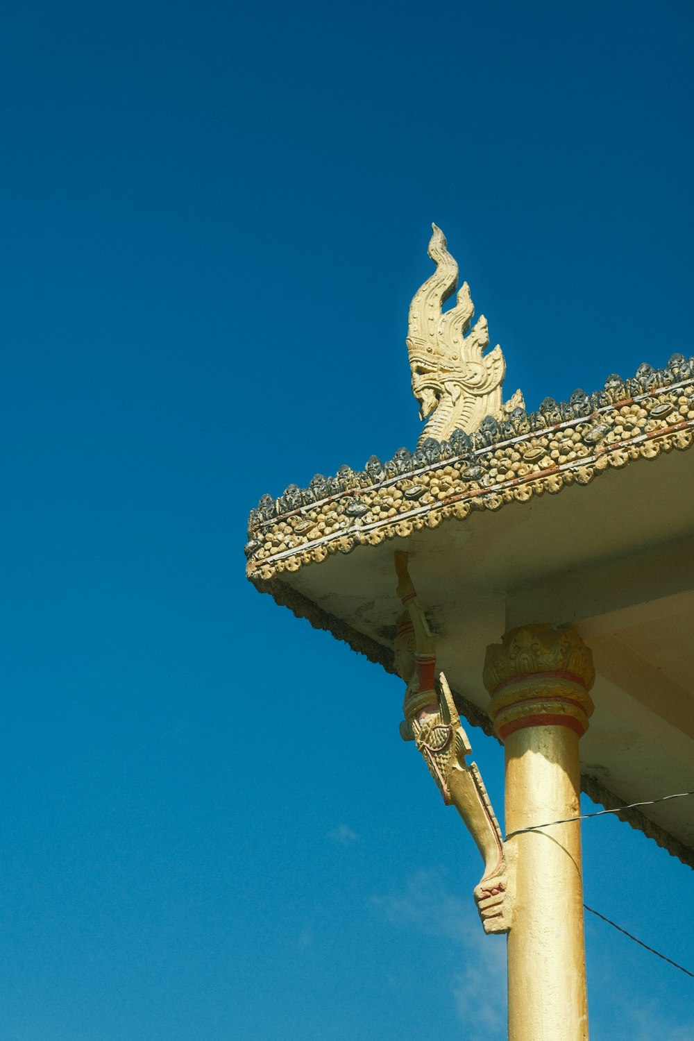 a statue on top of a building with a blue sky in the background