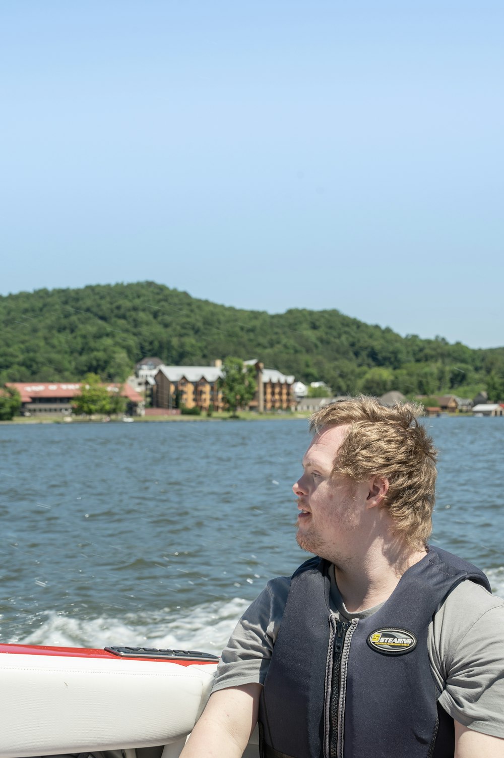 man in black and gray hoodie standing near body of water during daytime