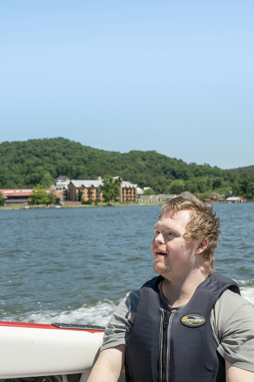 man in black and gray jacket standing near body of water during daytime