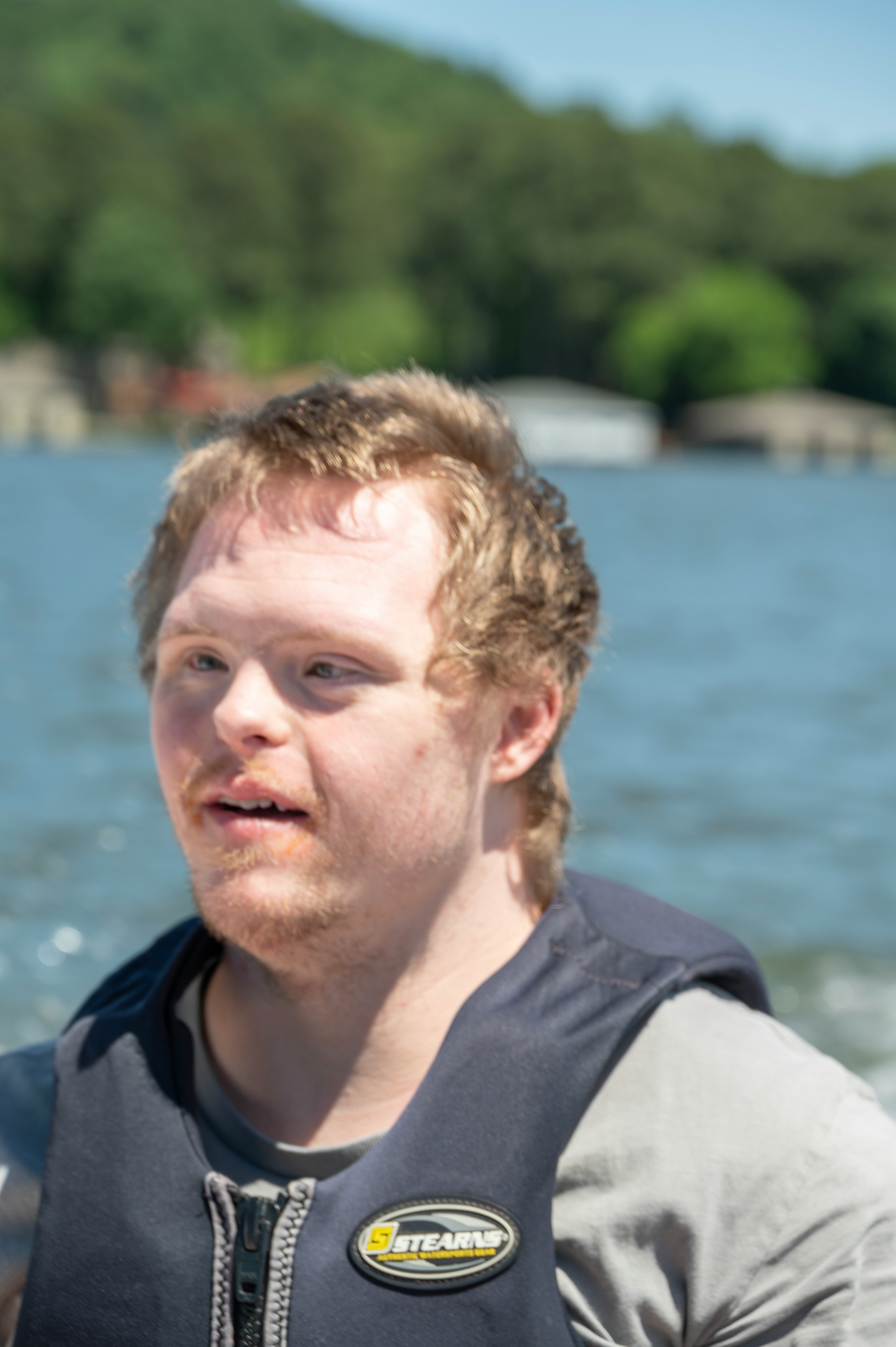 Man with Down syndrome smiling on a boat on a sunny day