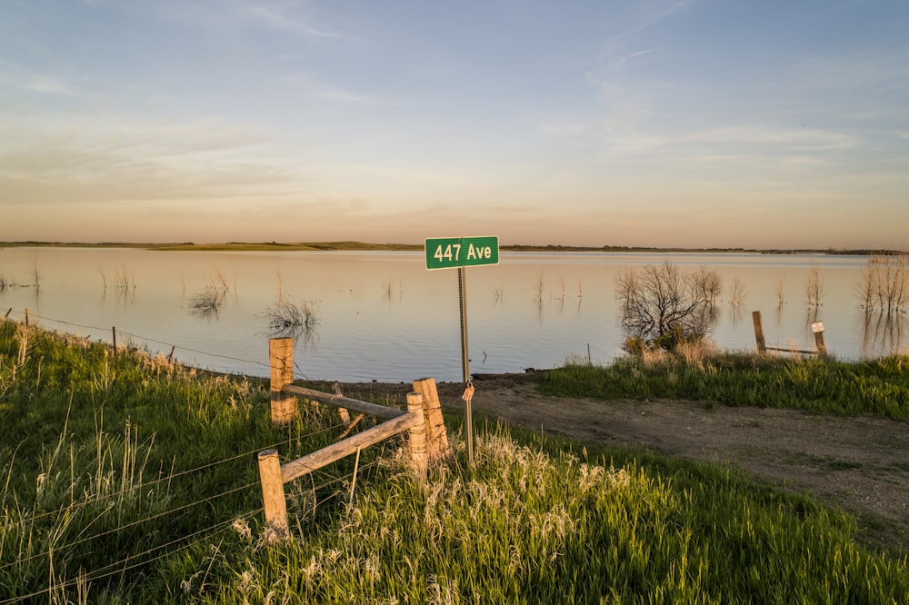 brown wooden fence near body of water during daytime