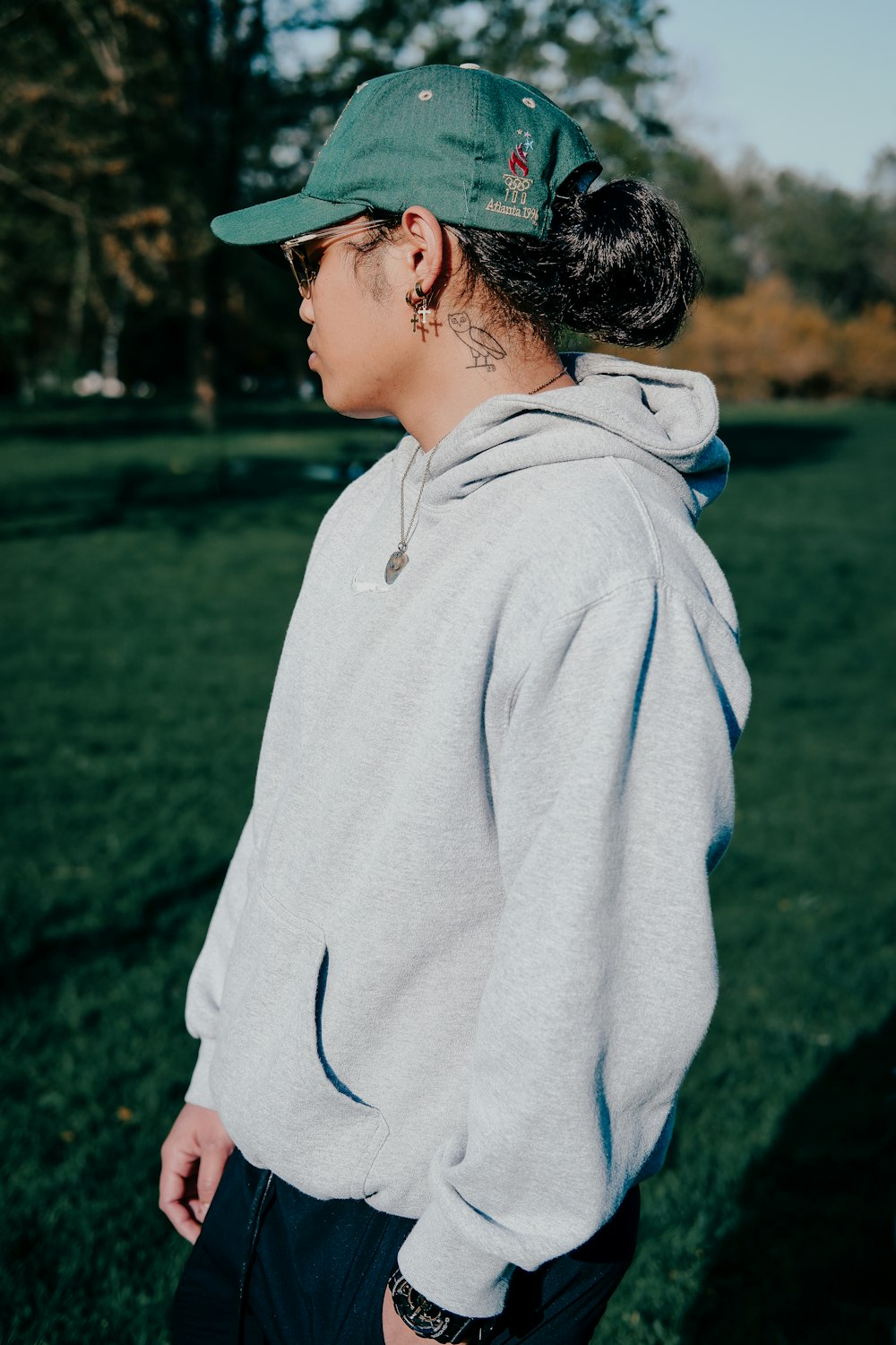 woman in white hoodie standing on green grass field during daytime