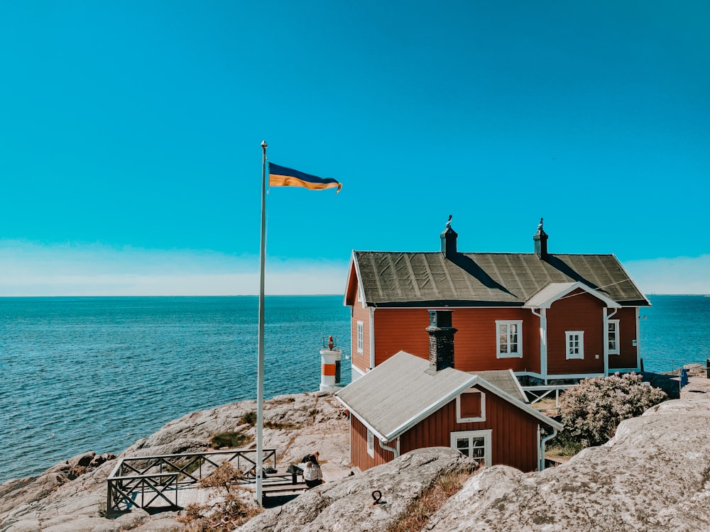 brown and white concrete house near body of water during daytime