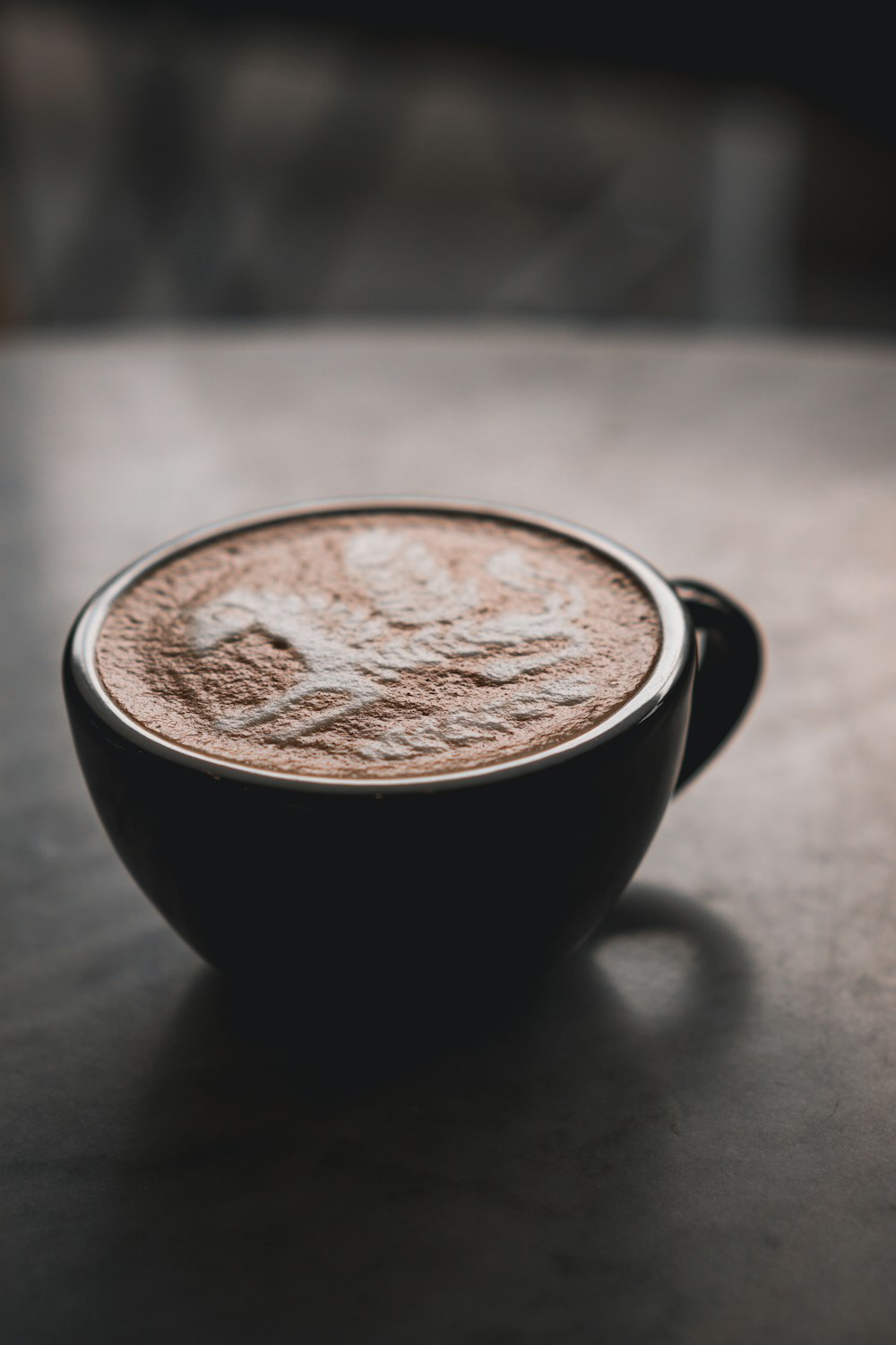 black ceramic mug with brown and white liquid