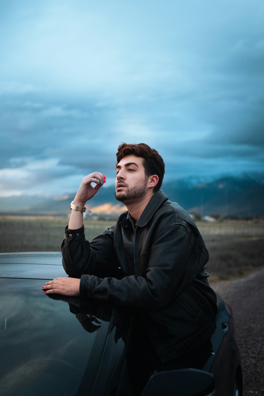 man in black jacket standing near body of water during daytime