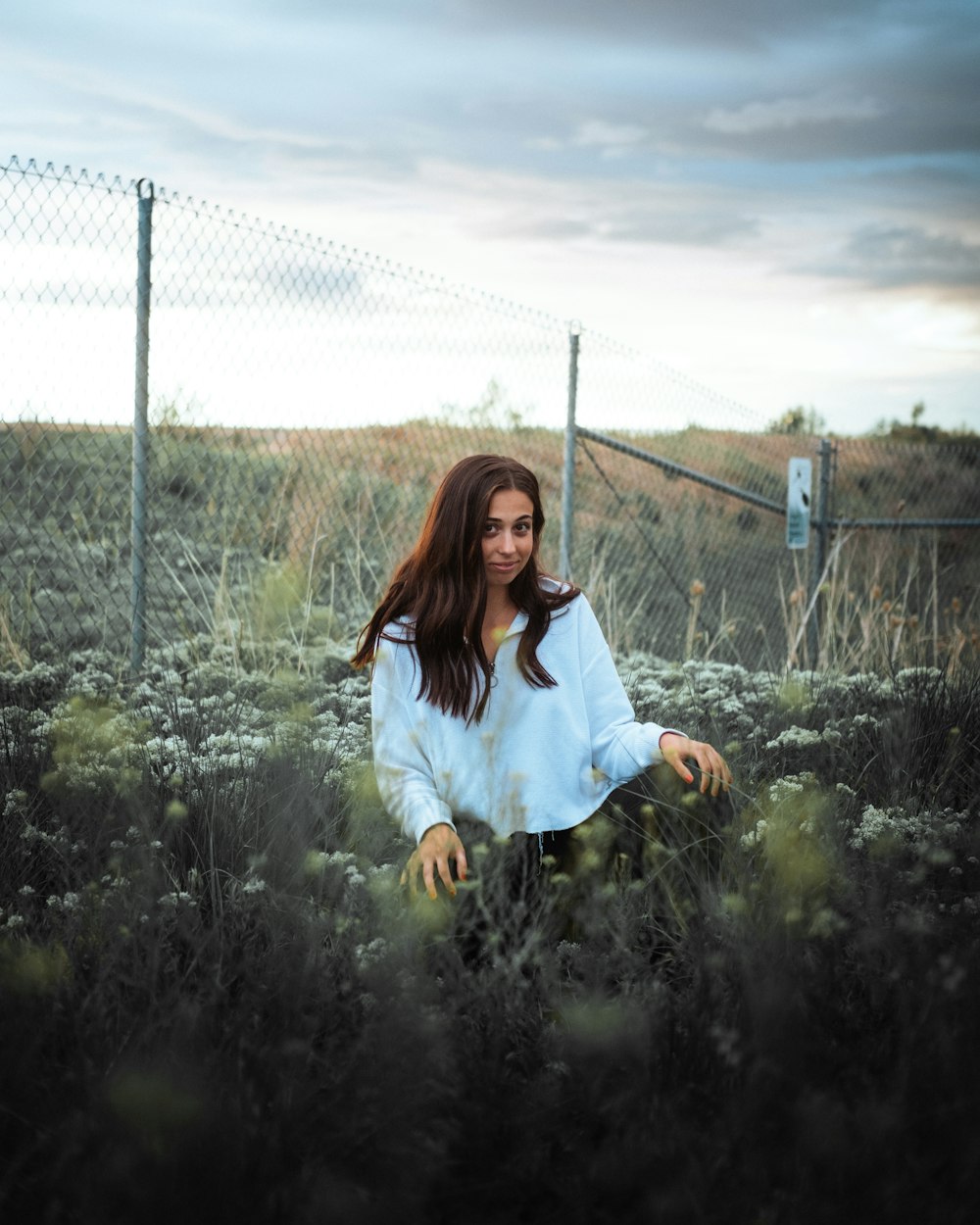 woman in white long sleeve shirt standing on green grass field during daytime