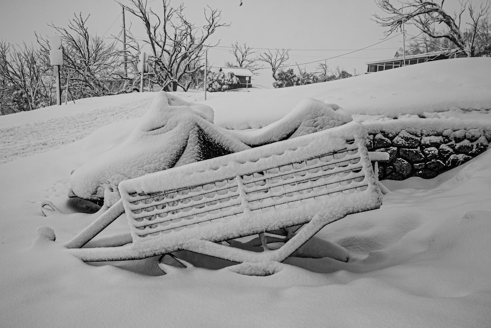 brown wooden bench covered with snow