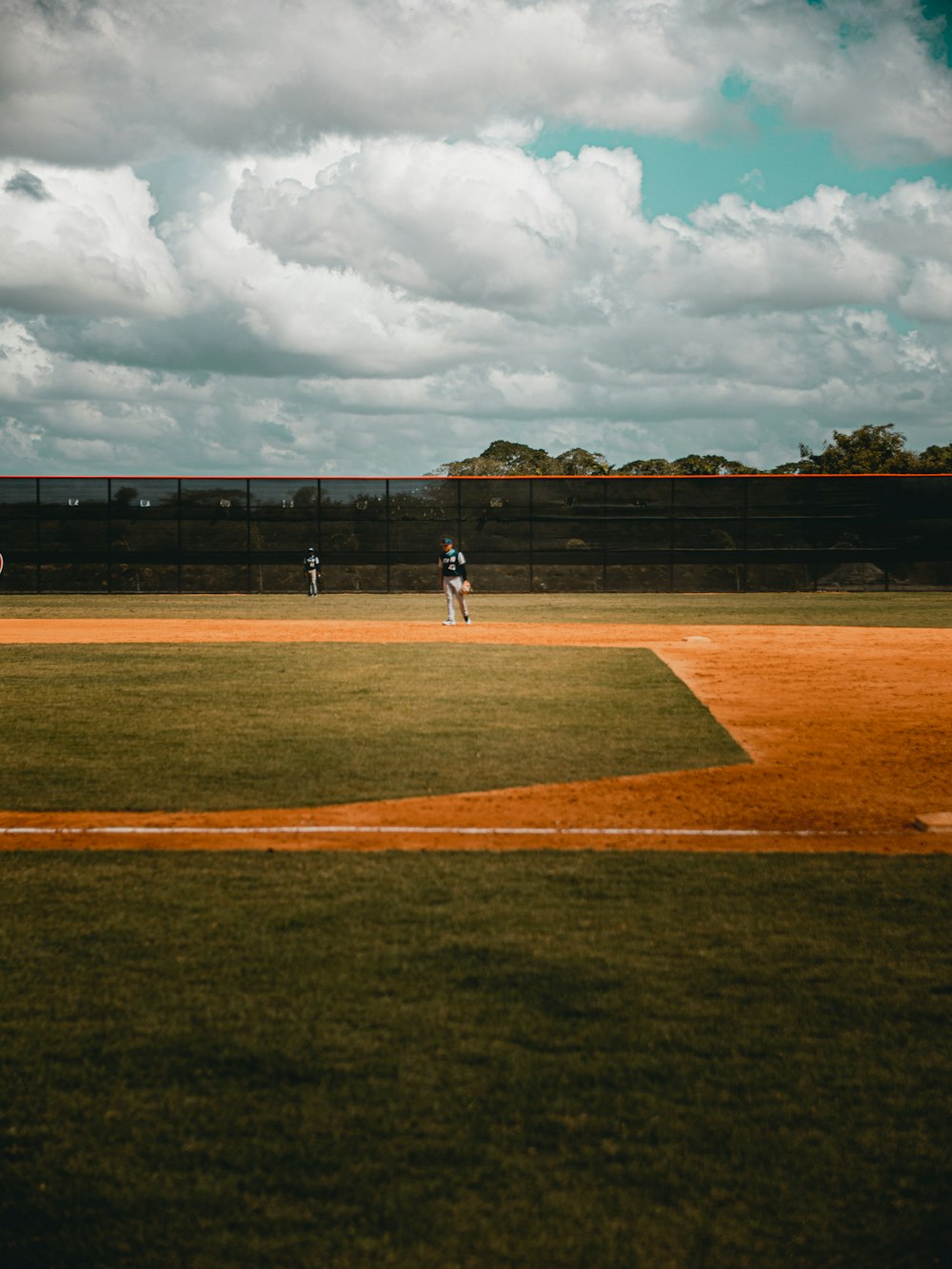 people playing baseball on field during daytime