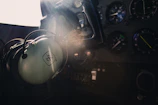 Close-up of sleek aviation smart glasses resting on a pilot's dashboard with digital flight data reflected on the lenses.