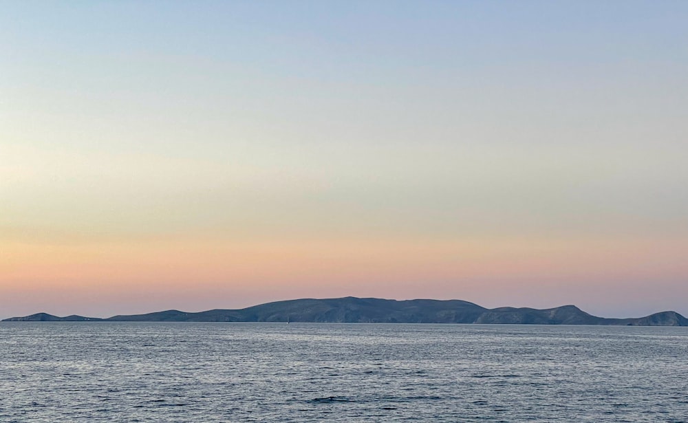 body of water near mountain during daytime