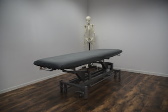 black bed frame on brown wooden parquet floor