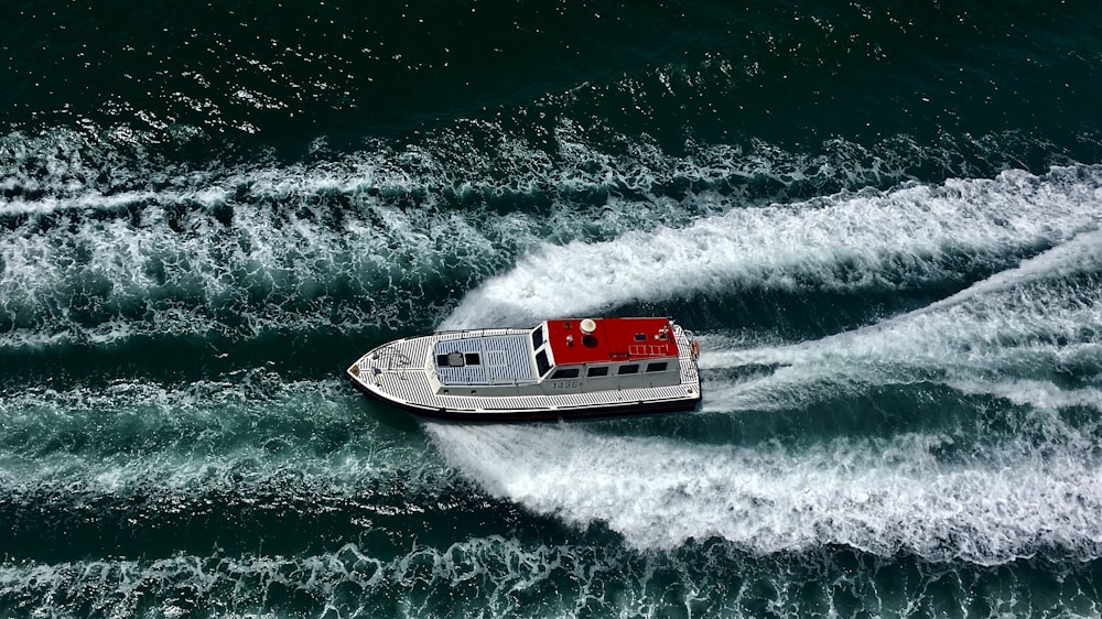 barco branco e vermelho no mar durante o dia