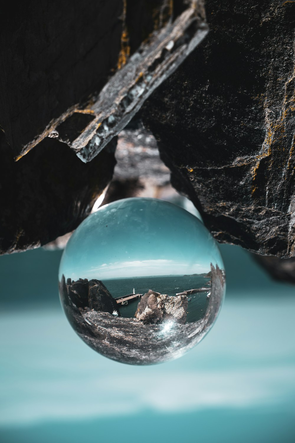 clear glass ball on black rock