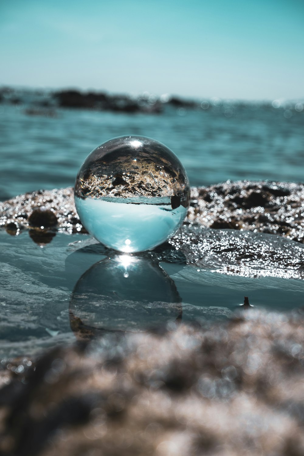 clear glass ball on black and white rock