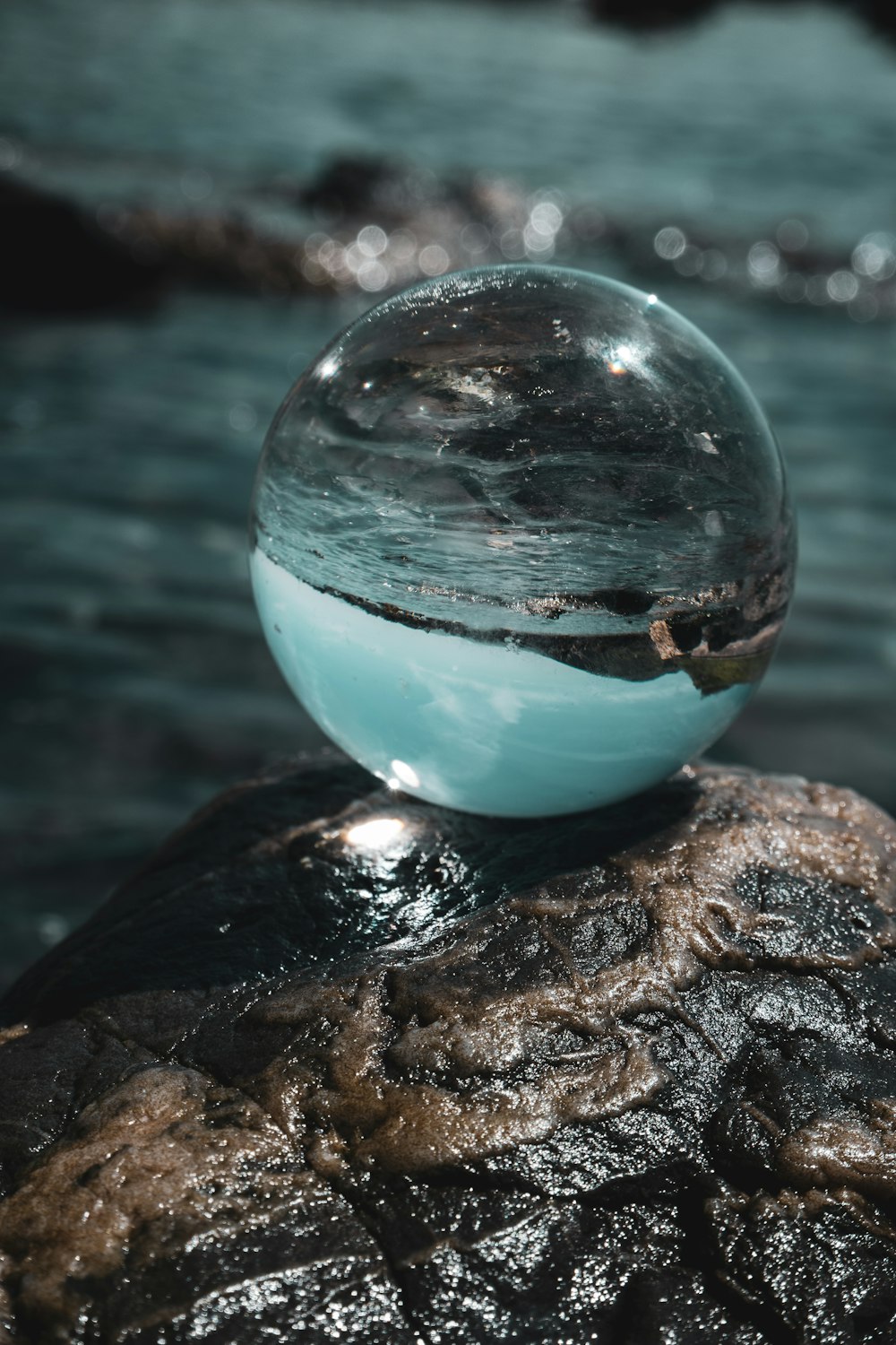 clear glass ball on brown rock