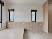 Minimalist room featuring violet-accented blinds casting soft shadows on black walls.