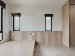 Minimalist room featuring violet-accented blinds casting soft shadows on black walls.