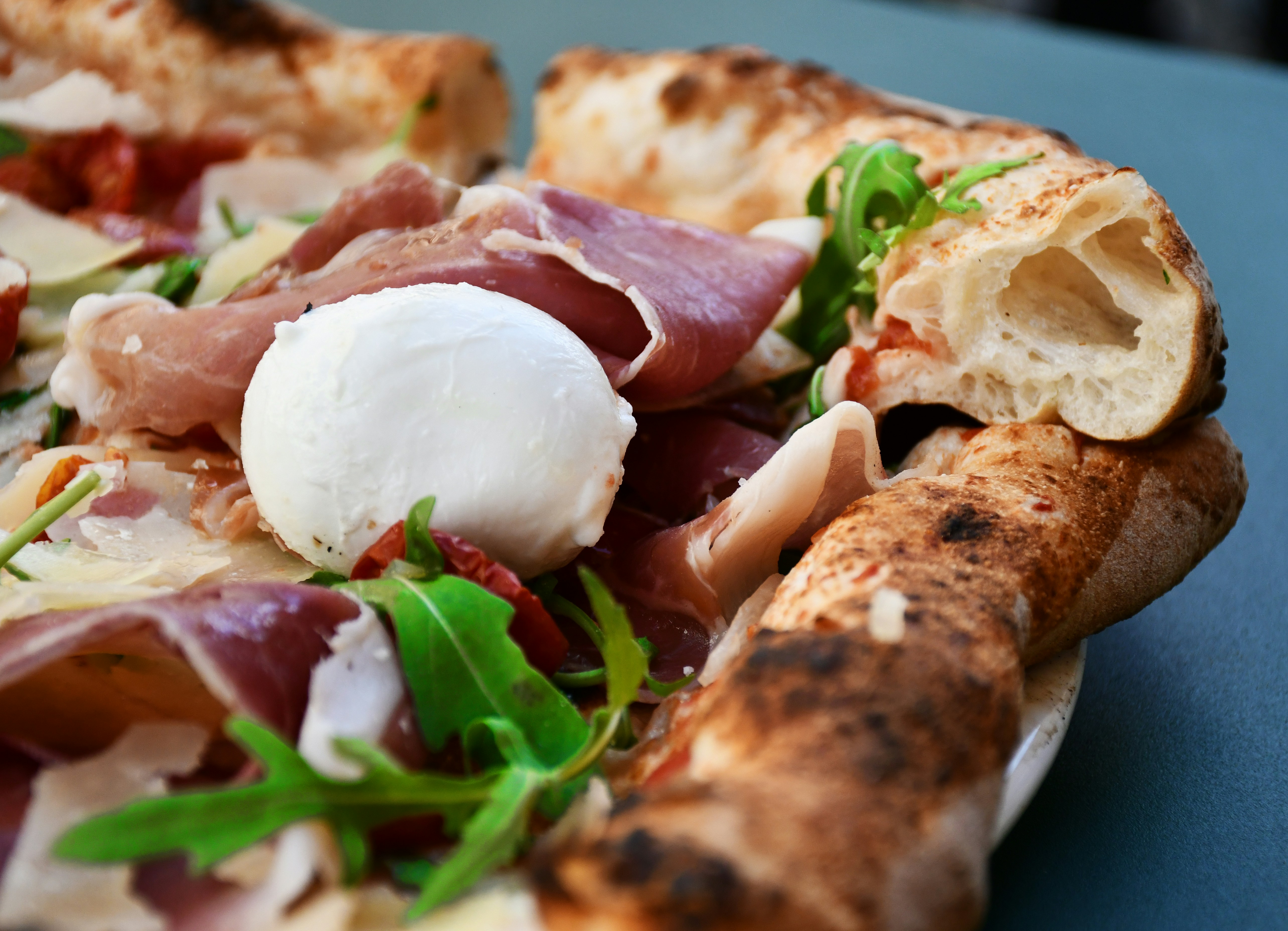 pizza with sliced tomato and green leaves