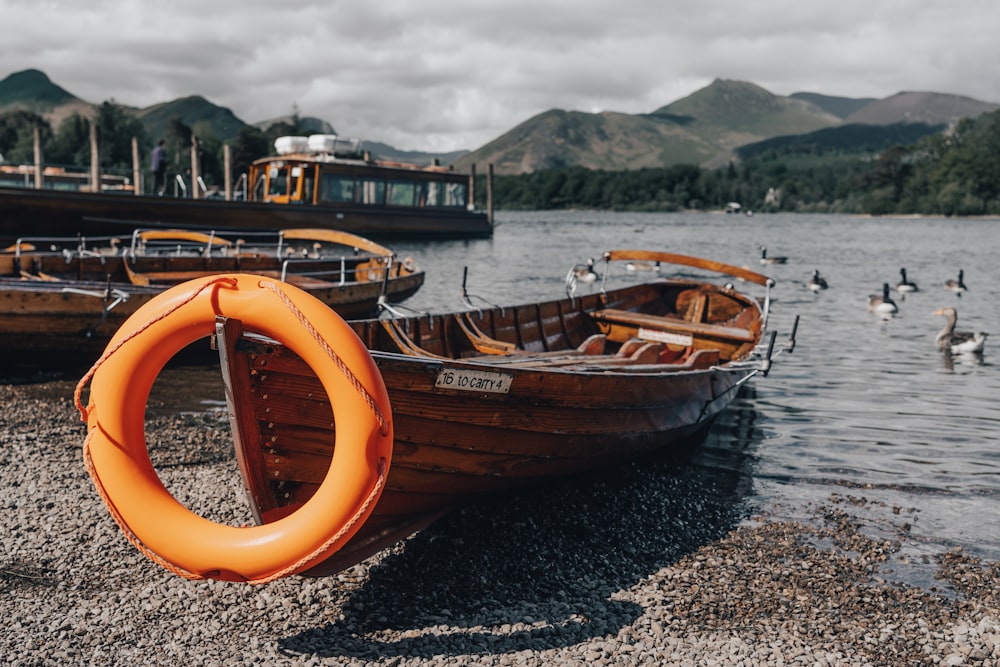 orange and white boat on sea shore during daytime