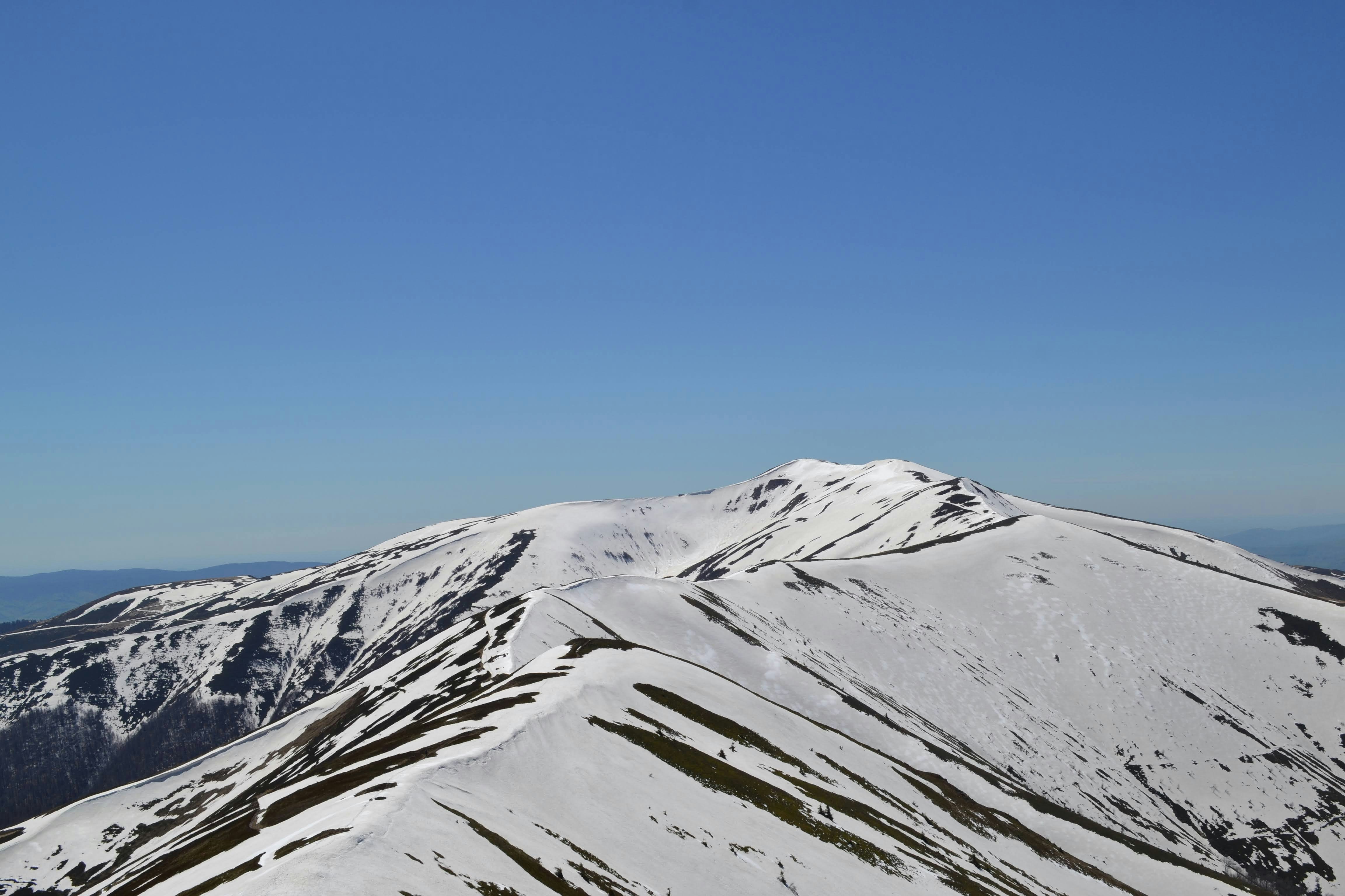 snow covered mountain under blue sky during daytime, Mountain range covered with snow