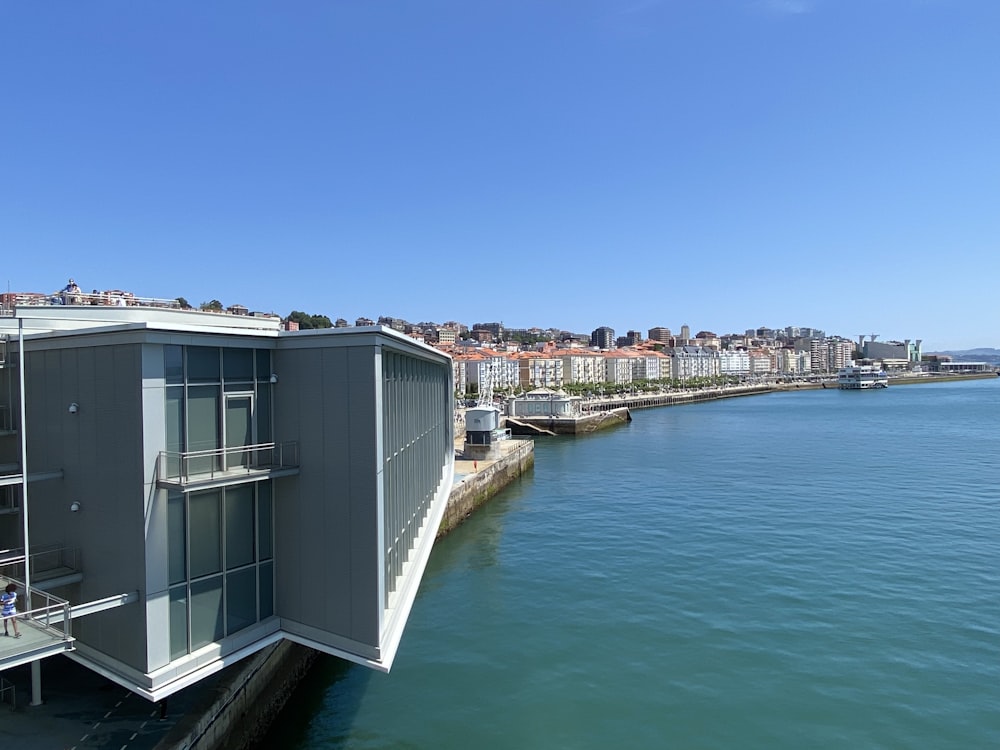 white and gray concrete building near body of water during daytime