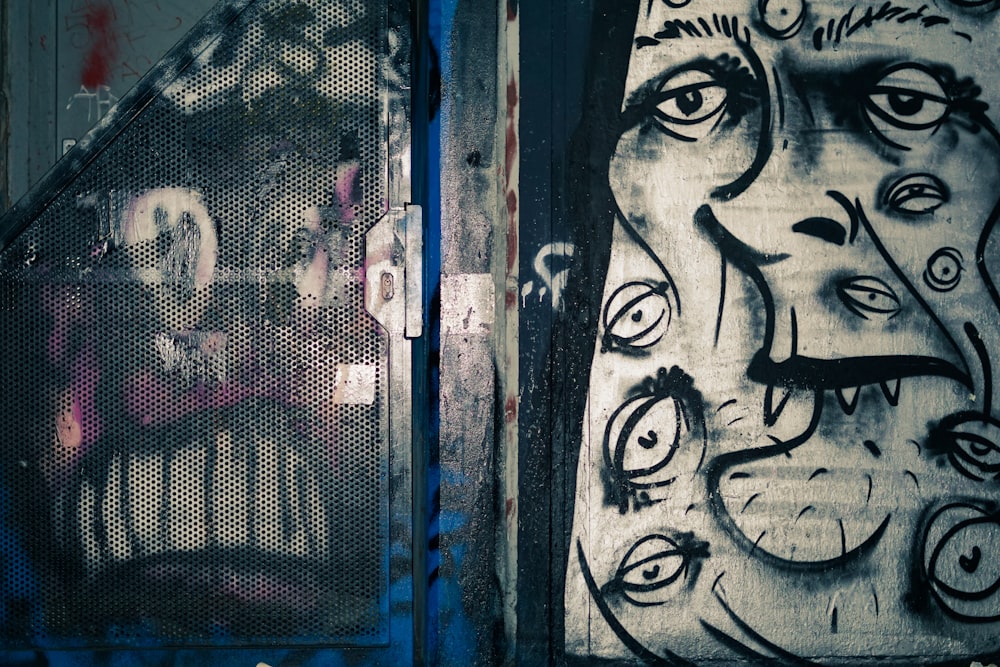 black and white graffiti on blue metal door