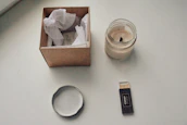Minimalist arrangement of Sylvan’s aroma pouches and candles on a soft grey surface with natural light.